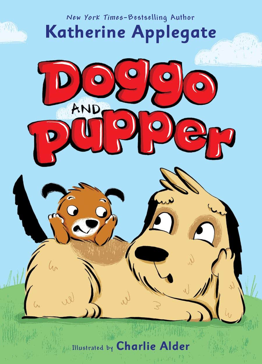 Book cover of “Doggo and Pupper” by Katherine Applegate, illustrated by Charlie Alder. It shows a small, excited brown dog playfully sitting on a larger beige dog lying on green grass, both with happy expressions.