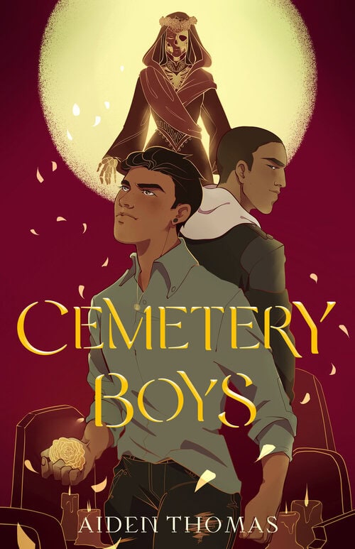Illustrated cover of Cemetery Boys by Aiden Thomas, featuring two boys standing back-to-back with serious expressions. A spectral, skeletal figure looms above them in a glowing circle. Yellow petals float around.
