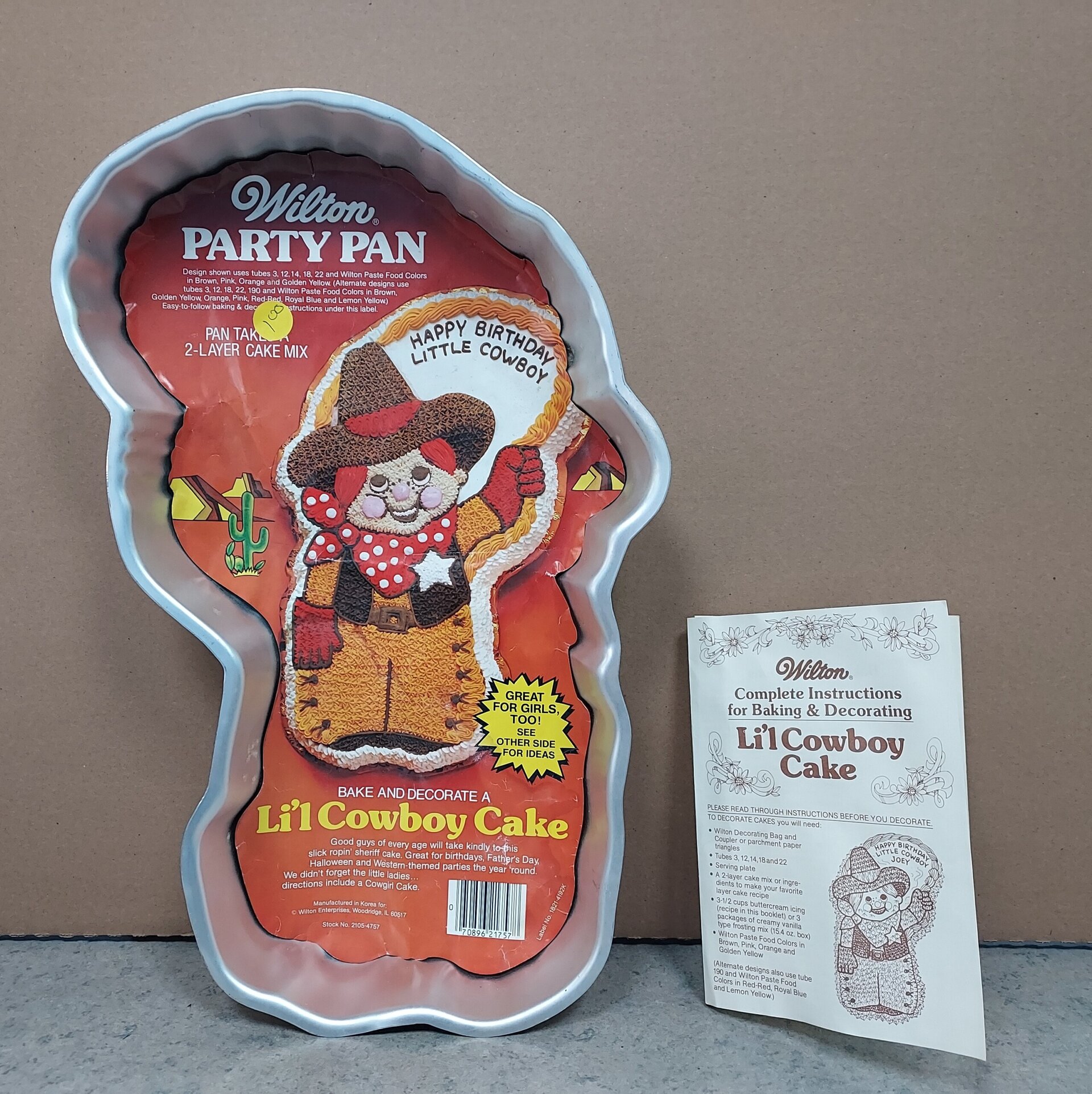 A Wilton party pan shaped like a cowboy with packaging showing a decorated cowboy bear cake. Next to it is an instruction sheet titled Lil Cowboy Cake with decorating and baking directions.