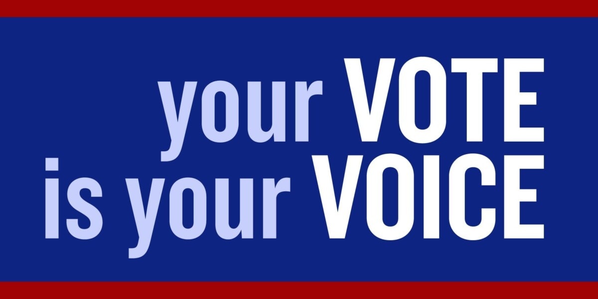 A blue rectangular sign with red borders displays the words your VOTE is your VOICE in bold, white and light blue capital letters.